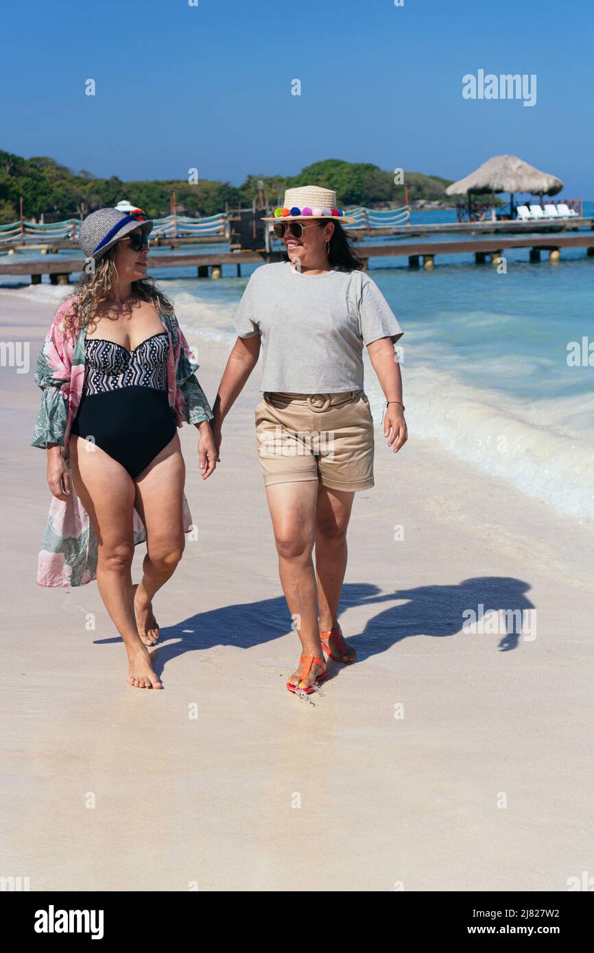 Two Women Walking On Beach Stock Photo - Alamy