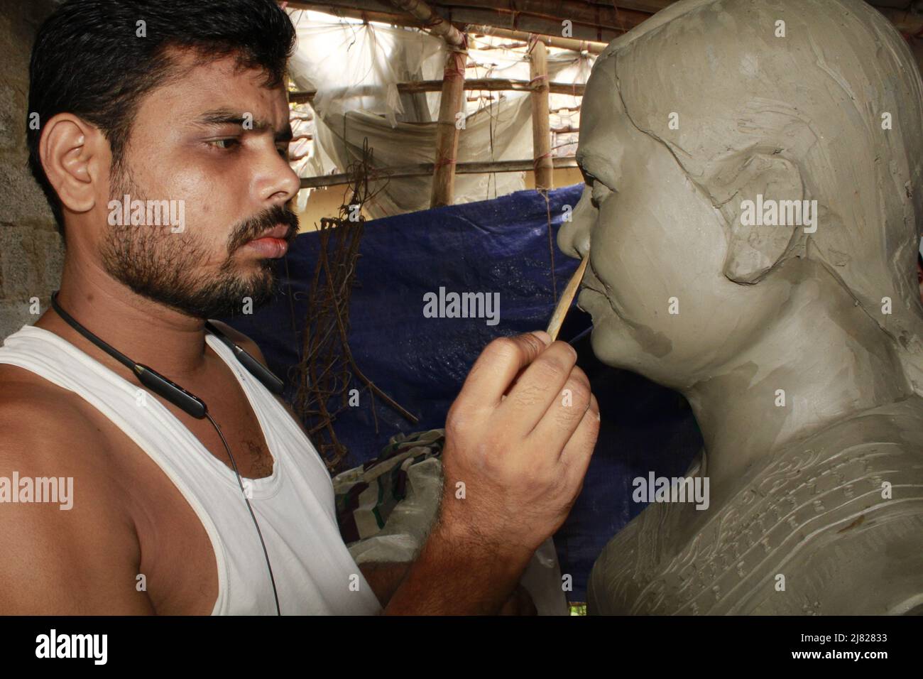 Man's hands making statue of clay. Stock Photo