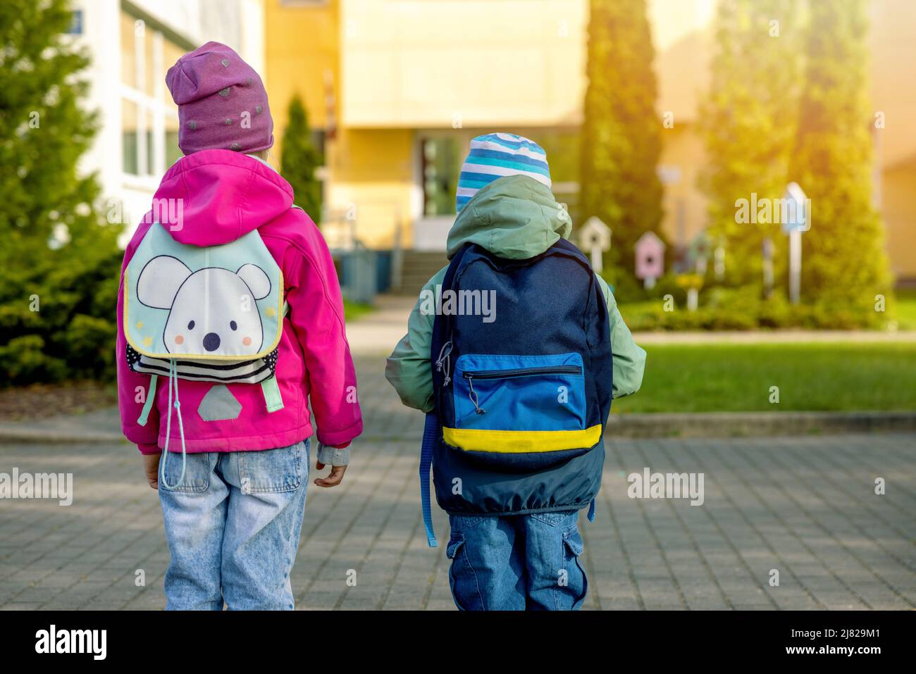 children with backpacks going to school in the morning. back view Stock Photo