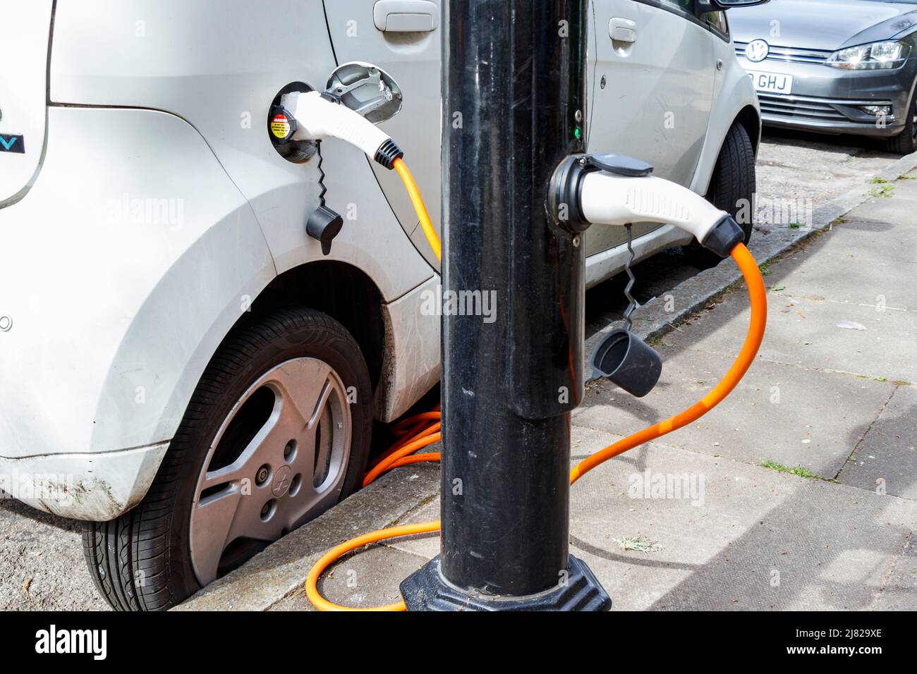 An electric vehicle recharging at a roadside lamp post recharging point,  London, UK Stock Photo