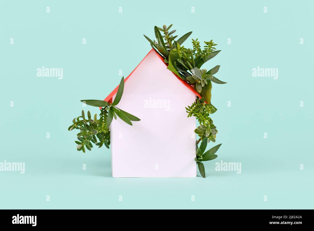 Concept for energy efficiency and carbon neutrality in buildings by using green construction designs and renewable energy showing house with leaves Stock Photo