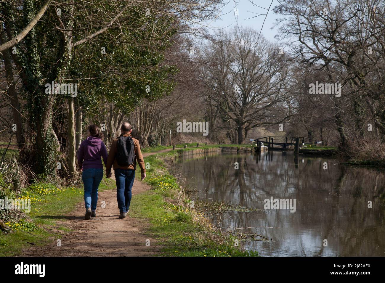 couple walking on tow path river wey navigation pyrford surrey england Stock Photo