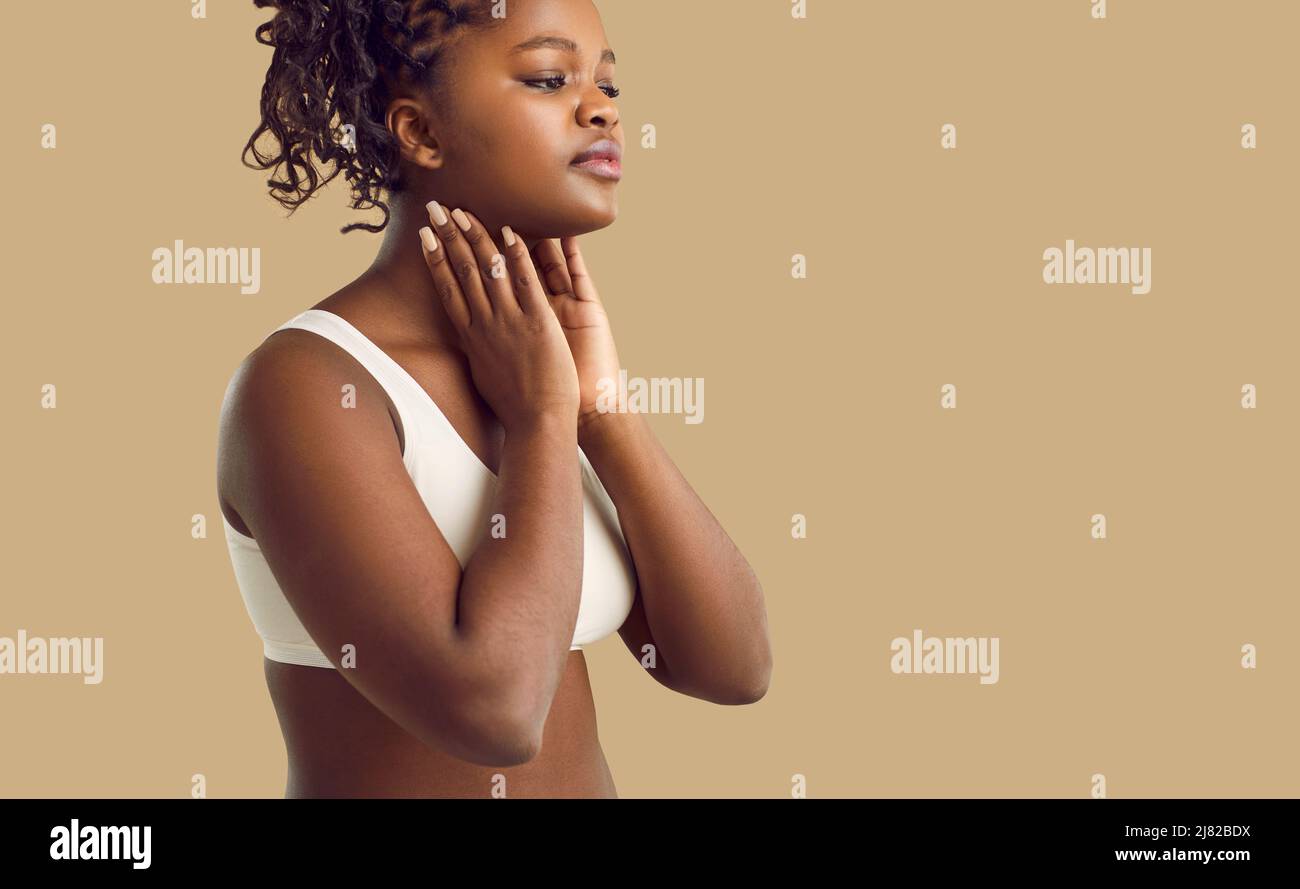 Black woman feeling pain in her throat due to inflamed lymph nodes or tonsil glands Stock Photo
