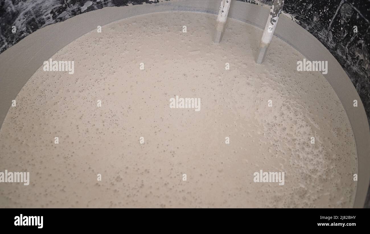 Mix the solution in a bucket using a construction mixer. The worker