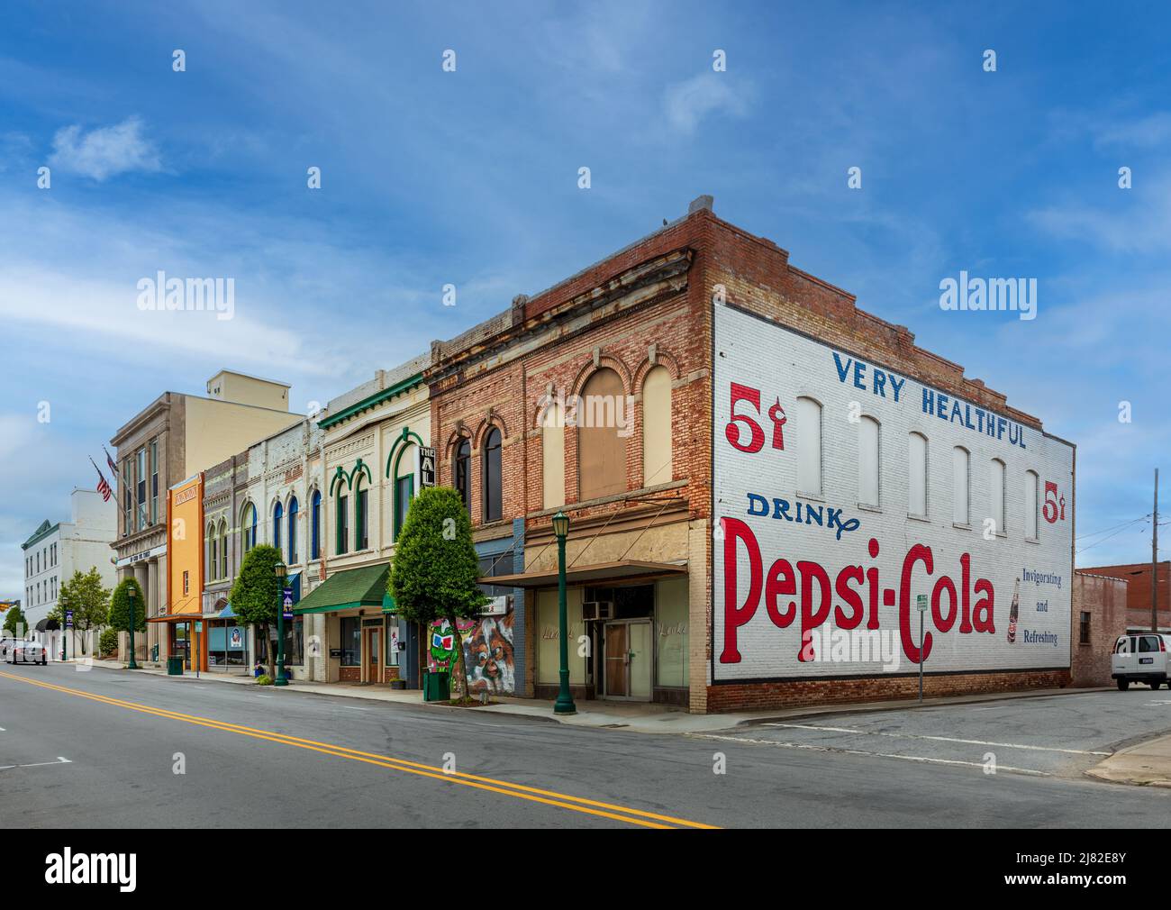 THOMASVILLE, NC, USA-8 MAY 2022: A block of vintage commercial buildings downtown, with a large painted Pepsi-Cola advertisement on end wall. Stock Photo