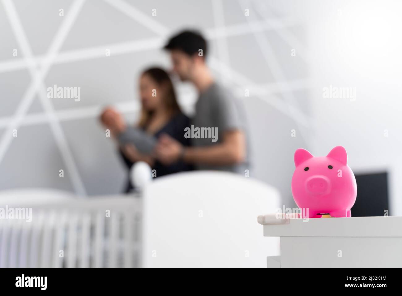 A couple of parents with their newborn baby with a piggy bank Stock Photo