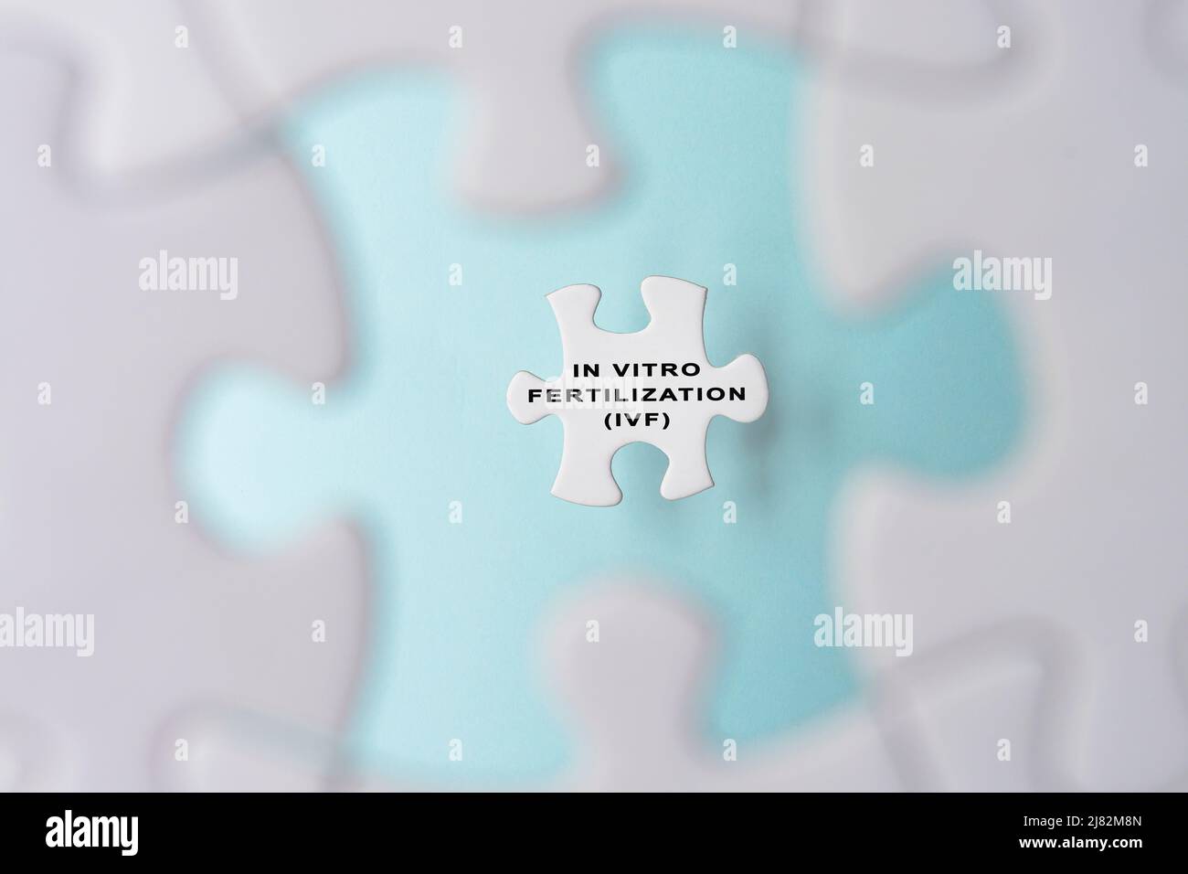 In Vitro Fertilization IVF word on puzzle pieces isolated on blue background. Stock Photo