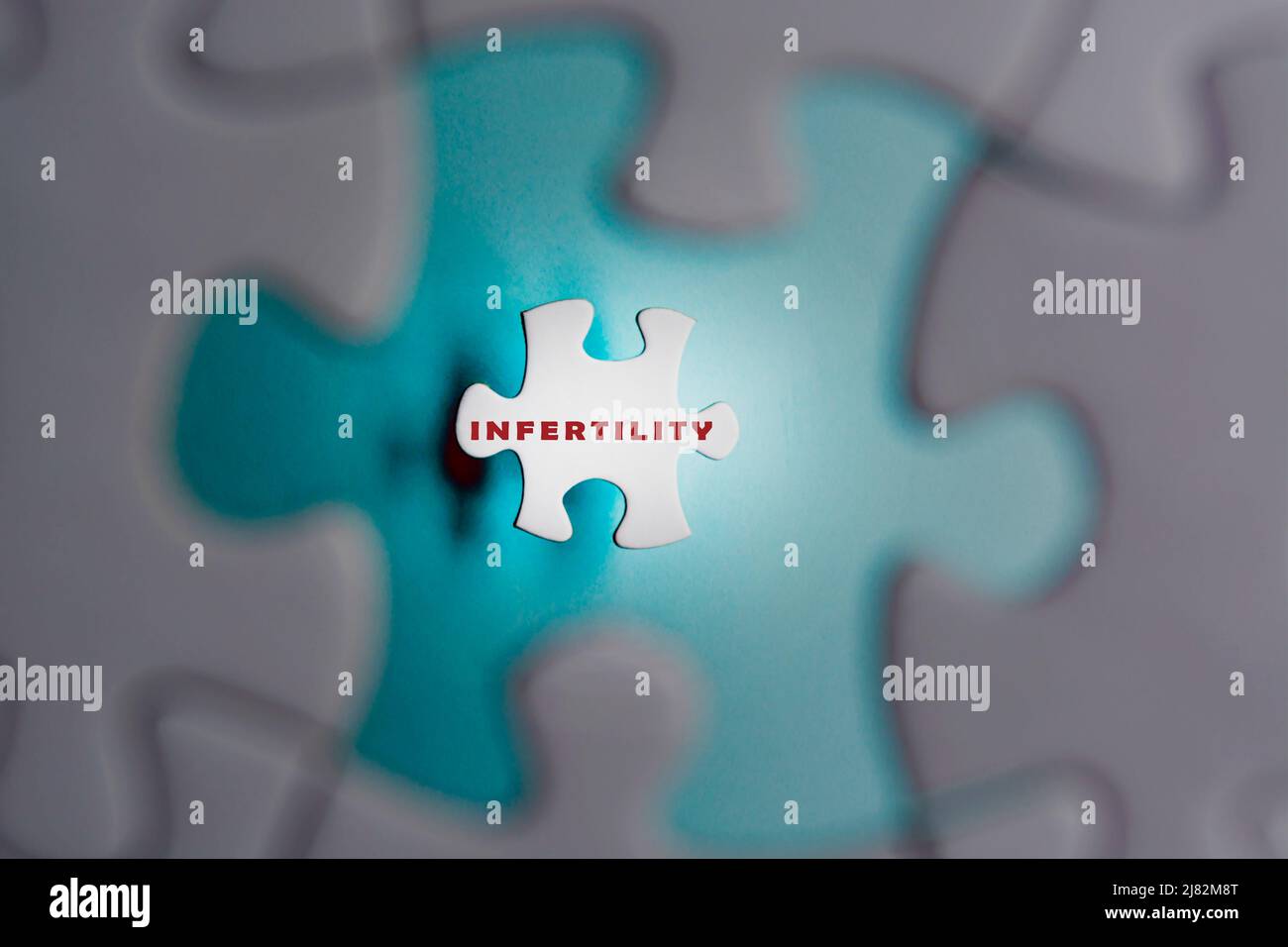 Infertility word on puzzle pieces isolated on blue background. IVF Treatment. Stock Photo