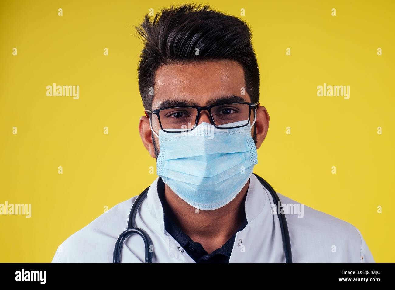 Young male doctor on yellow background in studio Stock Photo
