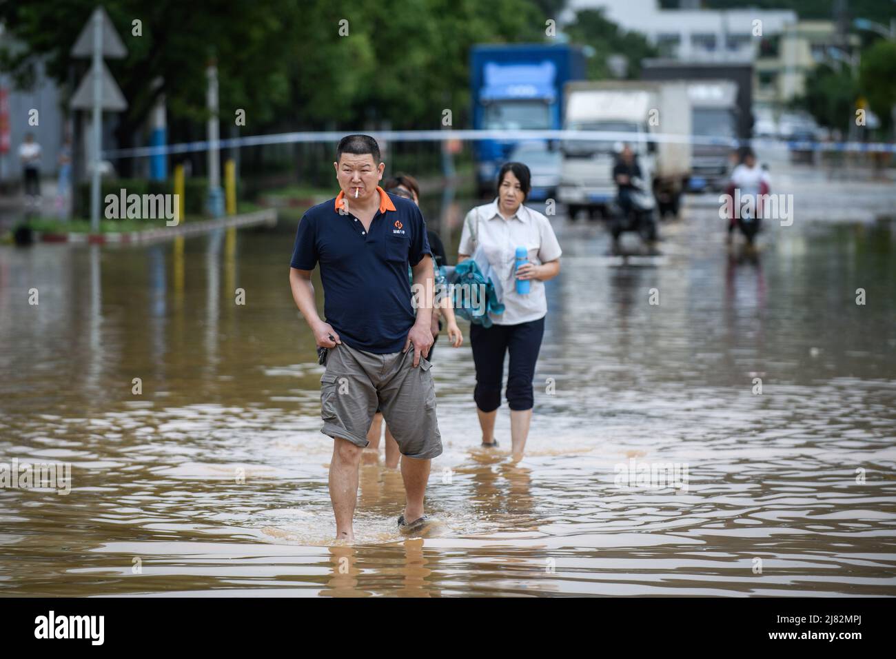 ZHONGSHAN, CHINA - MAY 12, 2022 - Citizens walk in a flooded street after a rainstorm in Zhongshan, Guangdong Province, China, May 12, 2022. Stock Photo