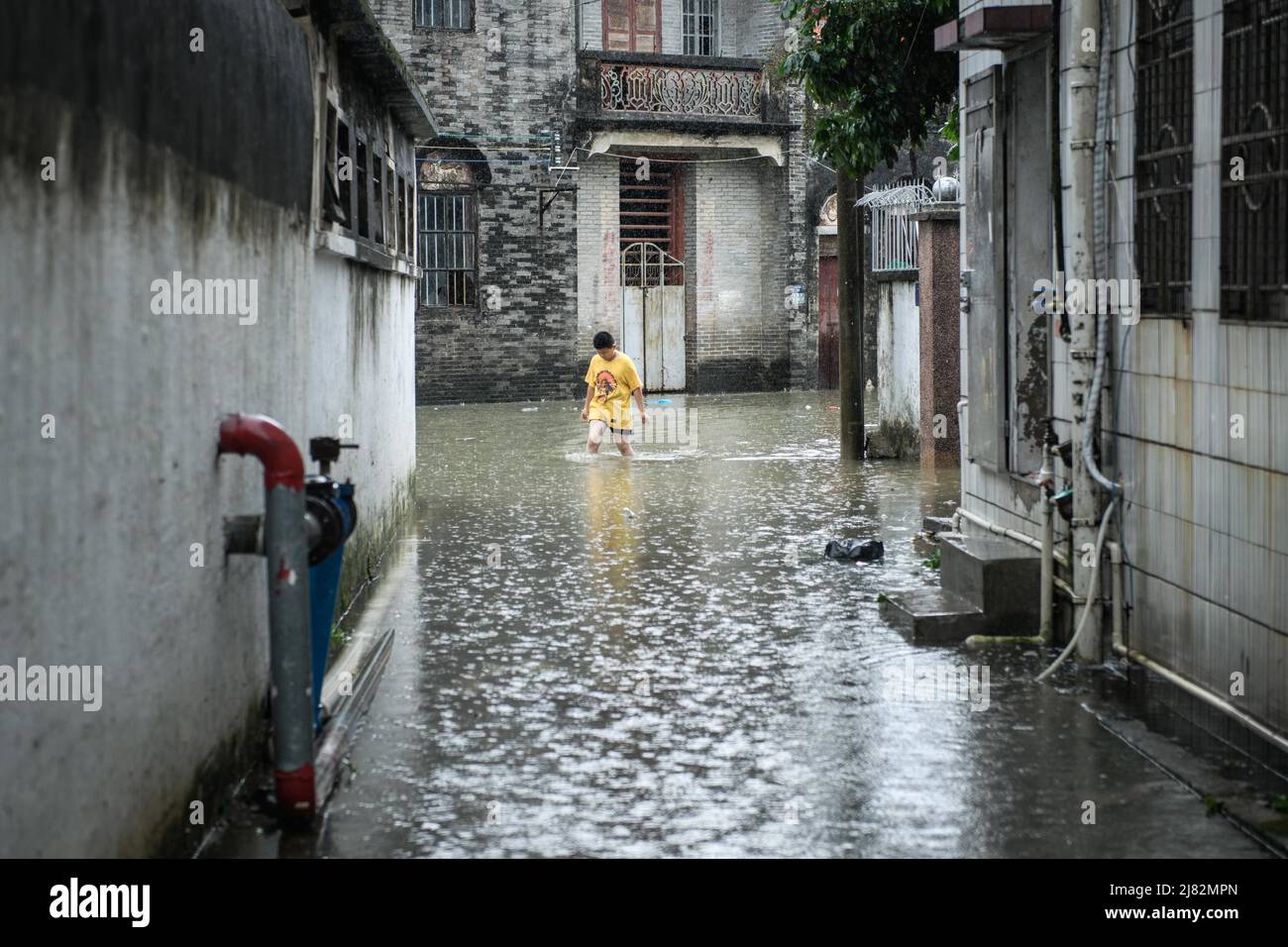 ZHONGSHAN, CHINA - MAY 12, 2022 - Citizens walk in a flooded street after a rainstorm in Zhongshan, Guangdong Province, China, May 12, 2022. Stock Photo