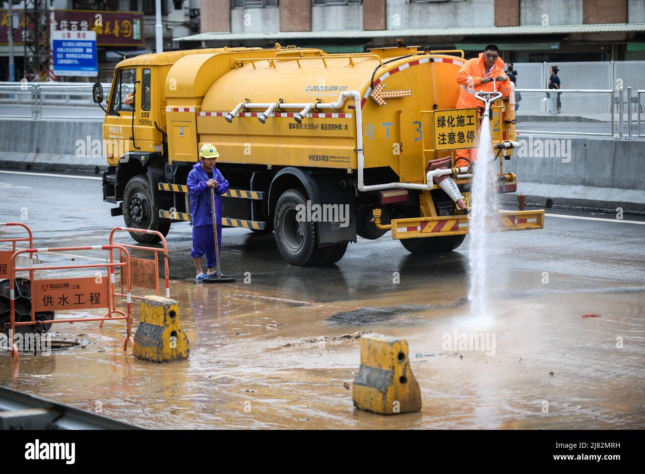 ZHONGSHAN, CHINA - MAY 12, 2022 - Cleaners clean a muddy street after a rainstorm in Zhongshan, Guangdong Province, China, May 12, 2022. Stock Photo