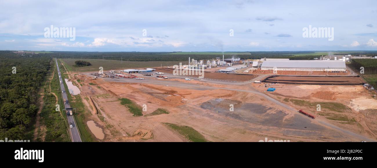 Panoramic drone aerial view of BR-163 road and deforested area with industrial factory building in the Amazon, Brazil. Ecology, urbanization. Stock Photo