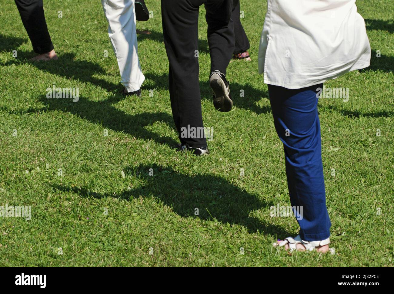 low section of people practicing tai chi in the park Stock Photo