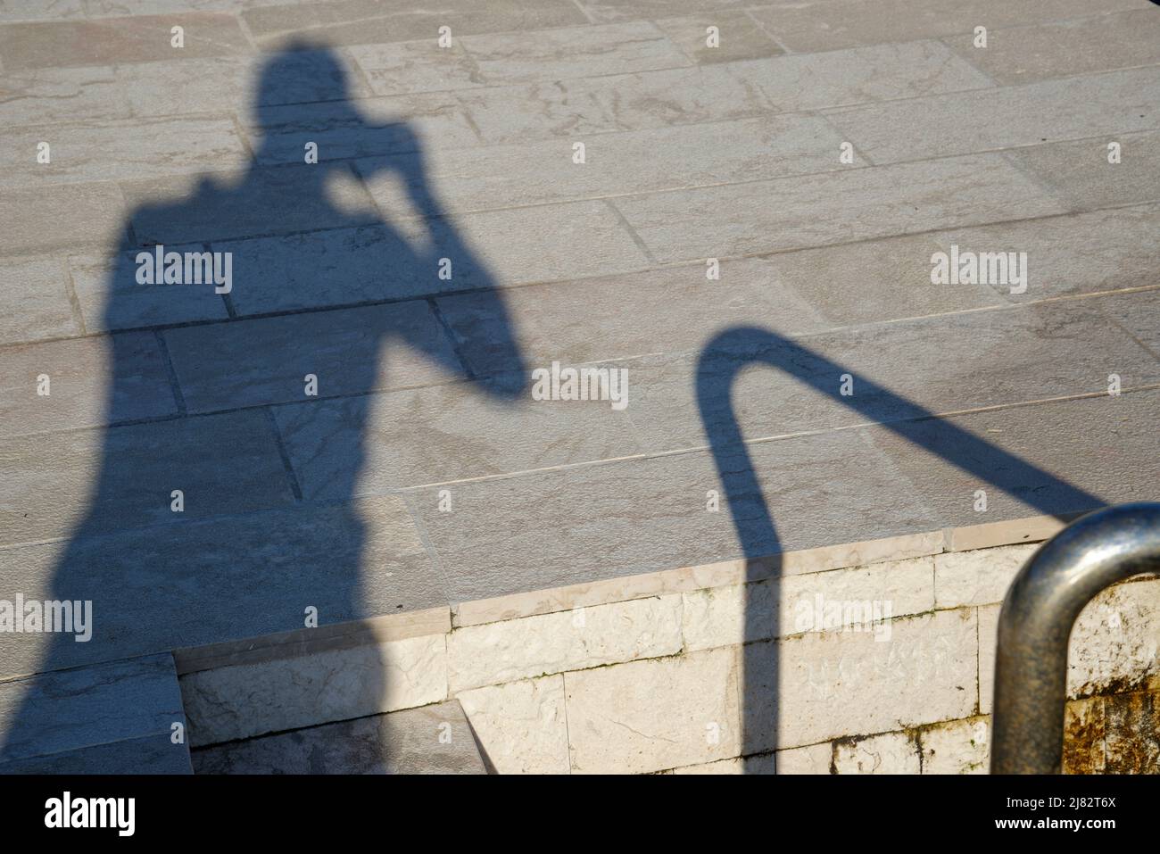 The shadow cast of a photographer taking snaps. A holiday hobbyist. Stock Photo