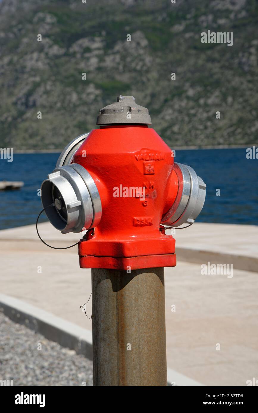 A new red fire hydrant by the sea in Montenegro. Stock Photo
