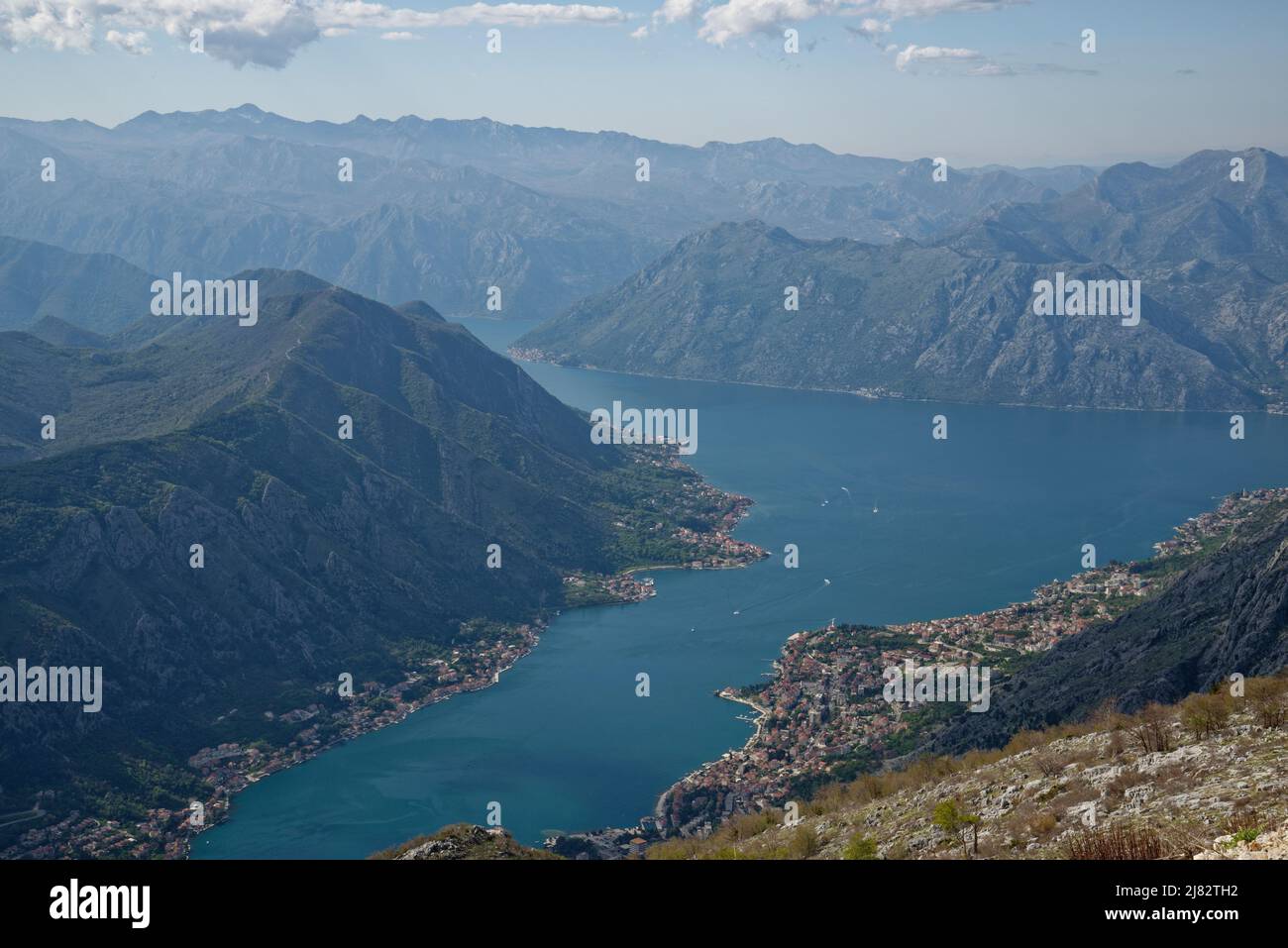 View of the bay of Kotor, Montenegro. Villages and the town of Kotor at the edge of the sea with dramatic surrounding mountains. Stock Photo