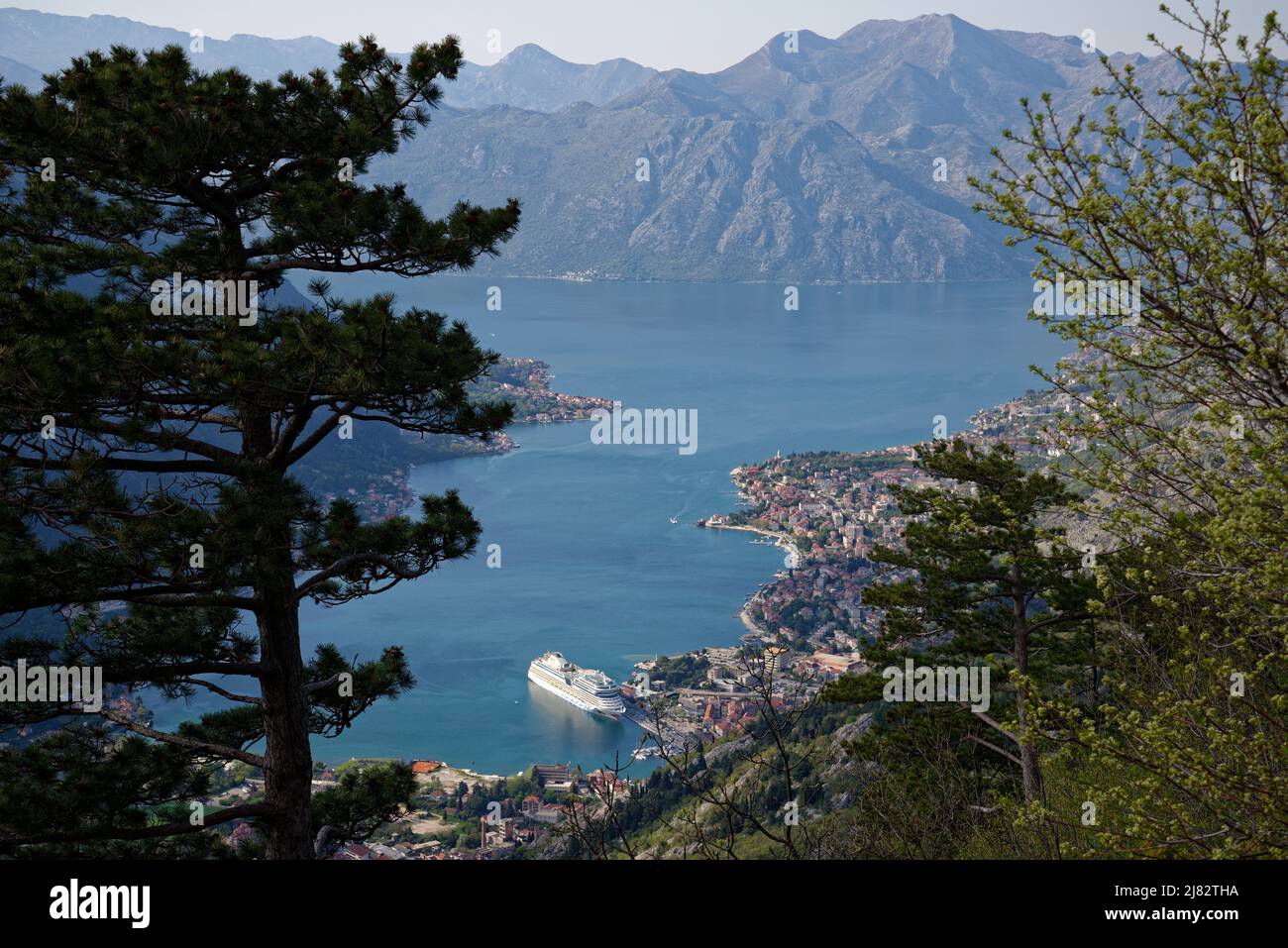 View of the bay of Kotor, Montenegro. Cruise ship at Kotor. Villages and the town of Kotor at the edge of the sea with dramatic surrounding mountains. Stock Photo
