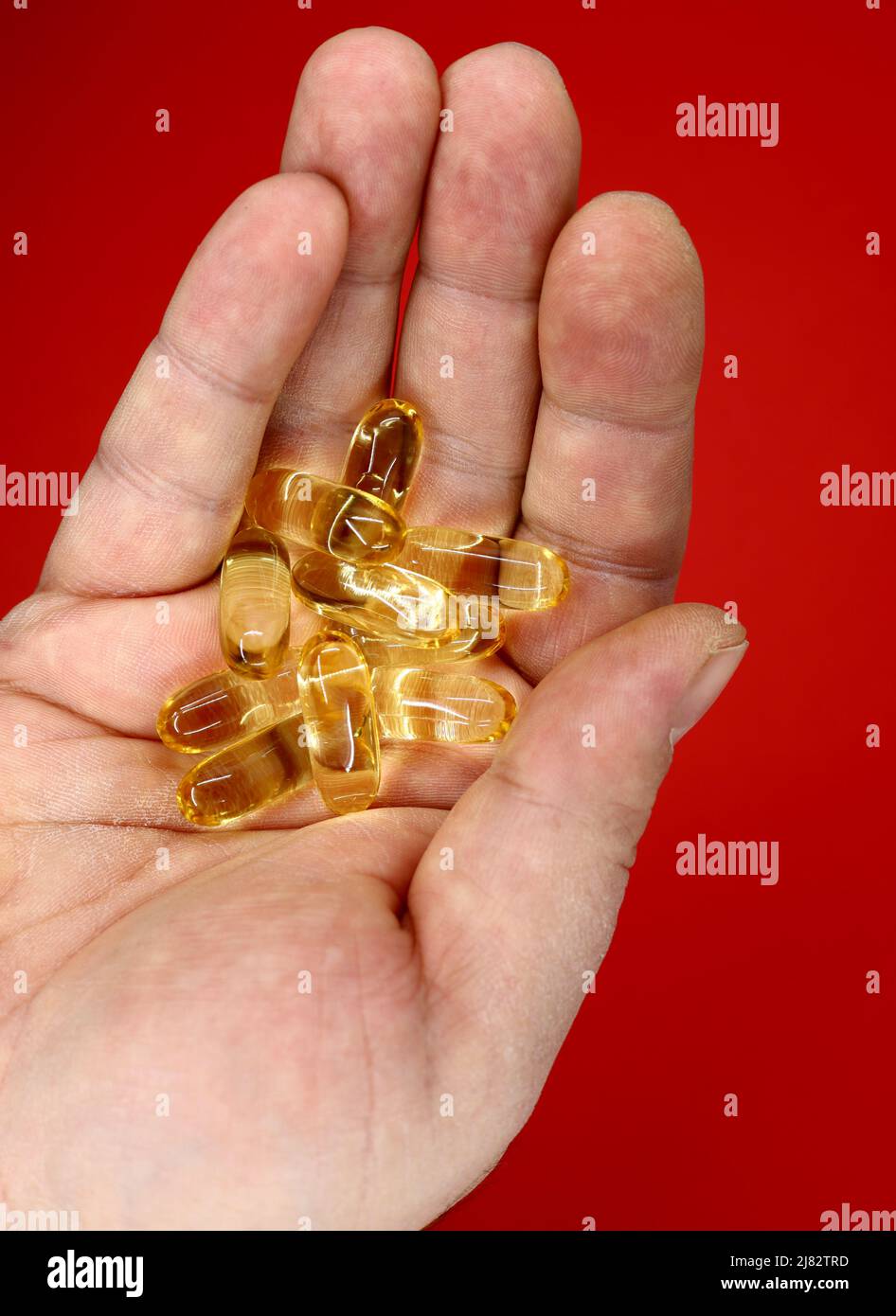 hand holding yellow medicine pill Stock Photo Alamy
