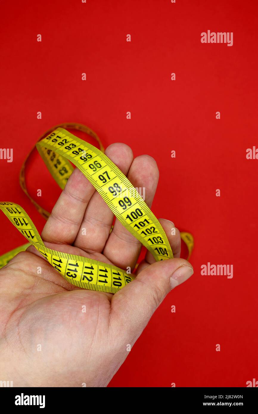 yellow measuring tape in a man's hand Stock Photo