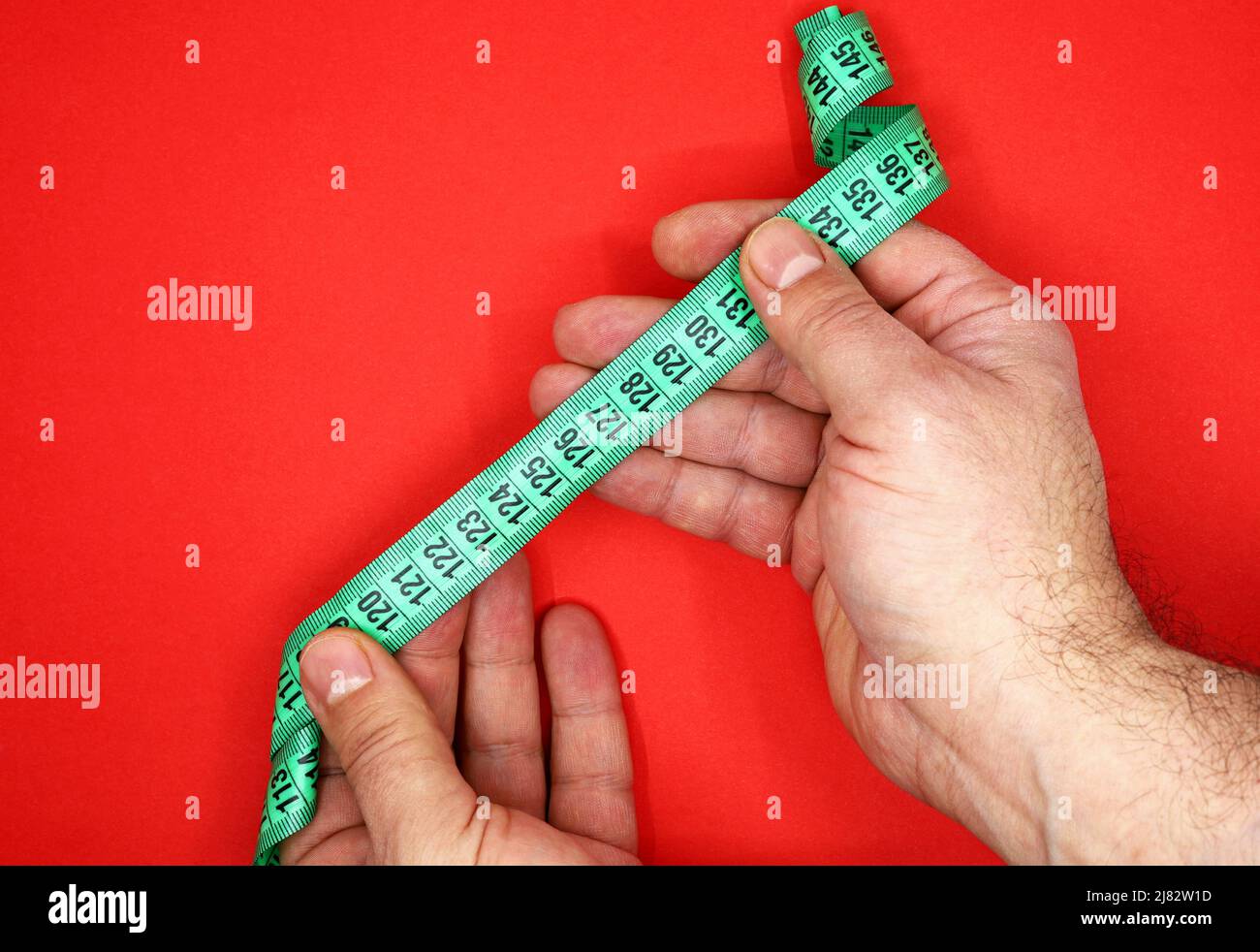 green measuring tape in a man's hand Stock Photo