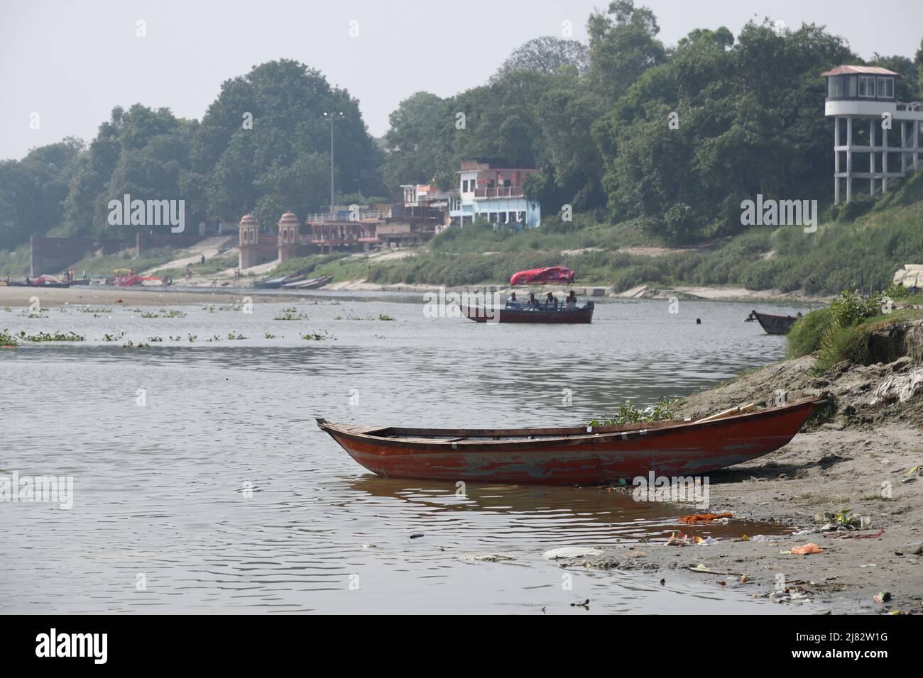 Floating desi boats in shallow riverbed of the holy Ganges in scorching
