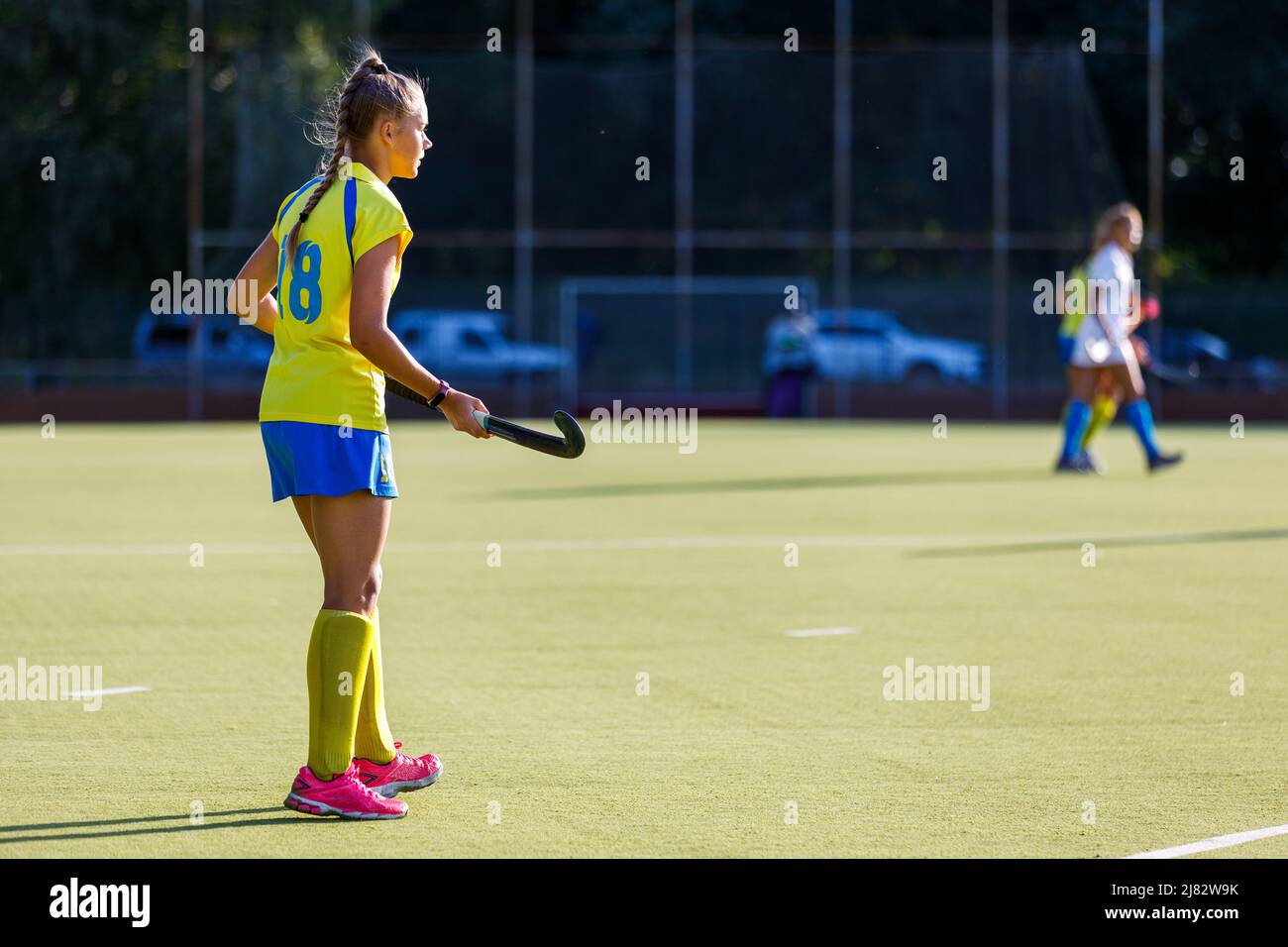 Young field hockey female player with stick during the game Stock Photo
