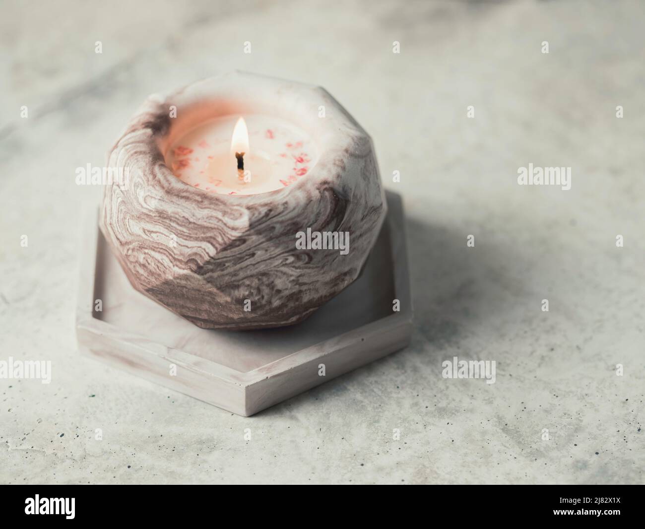 Soy candle in a concrete, plaster candlestick, decor interior. Home