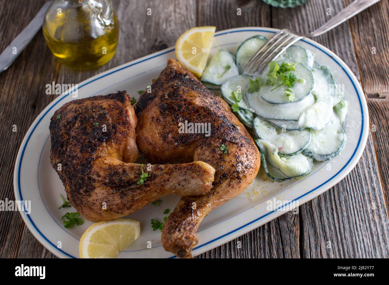 Chicken legs with cucumber salad on a plate Stock Photo