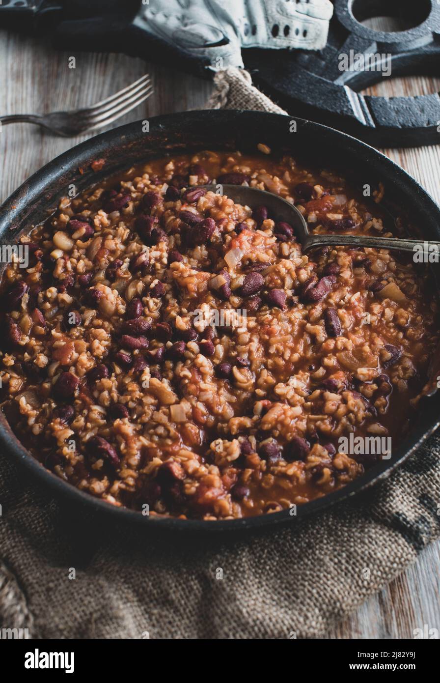 Healthy fitness food with a vegan muscle building dish cooked with brown rice, kidney beans, vegetables and tomato sauce. Stock Photo