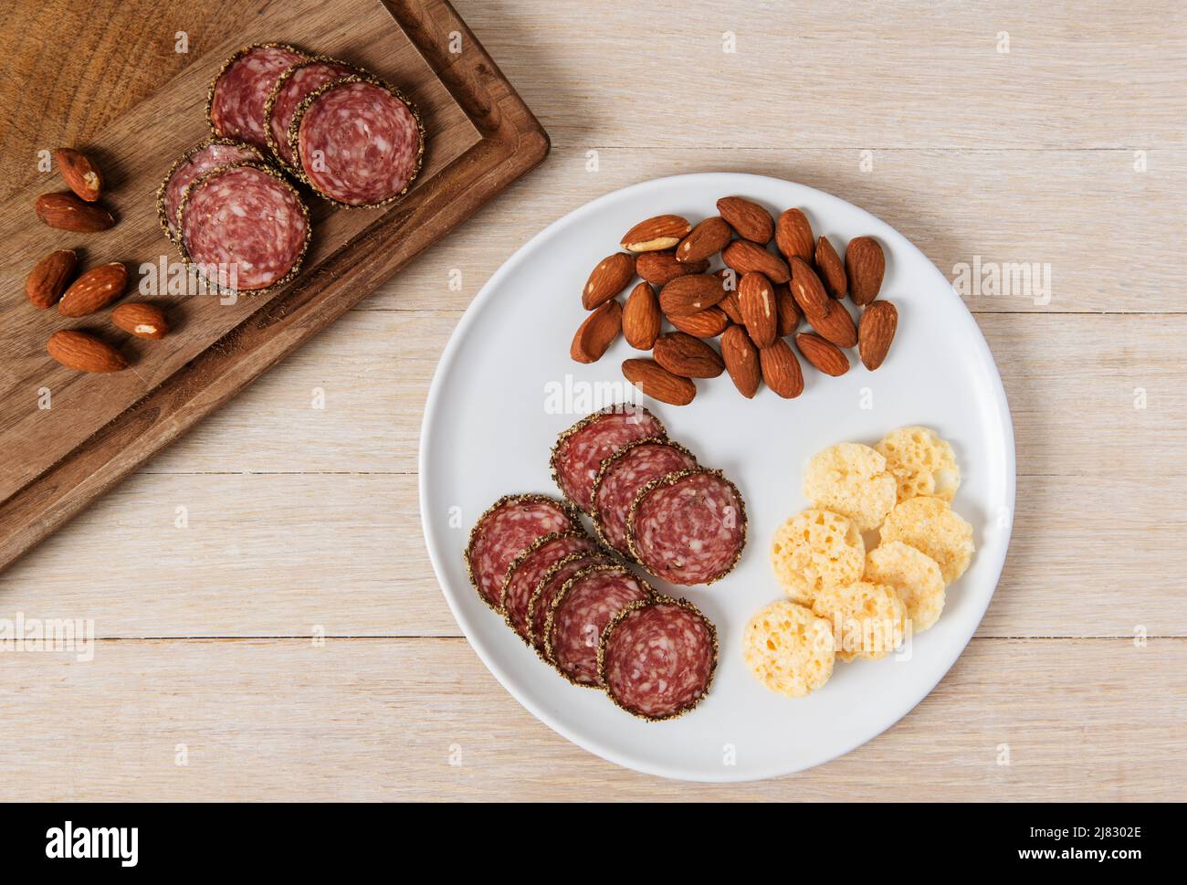 Appetizer snack of salami, almonds and Parmesan crisps Stock Photo Alamy