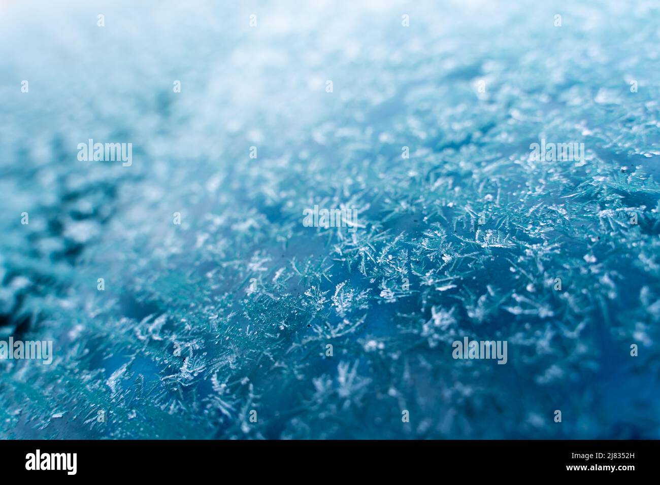 The windshield of the car is covered with frost and frostbite closeup