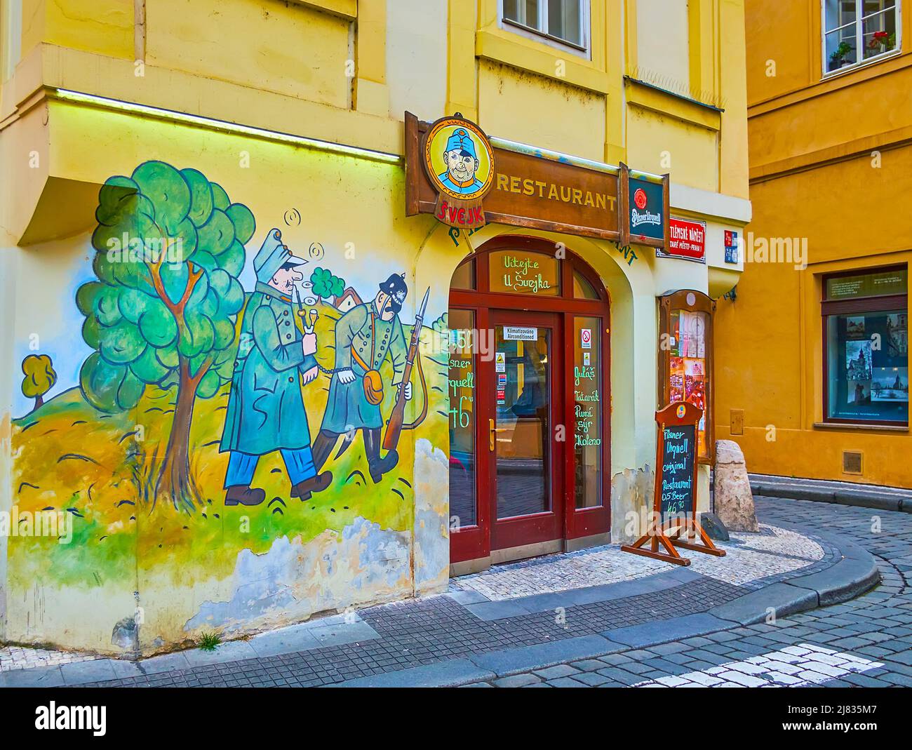 PRAGUE, CZECH REPUBLIC - MARCH 5, 2022: The facade of Svejk Restaurant on Bethlehem Square, decorated with colorful murals, on March 5 in Prague Stock Photo