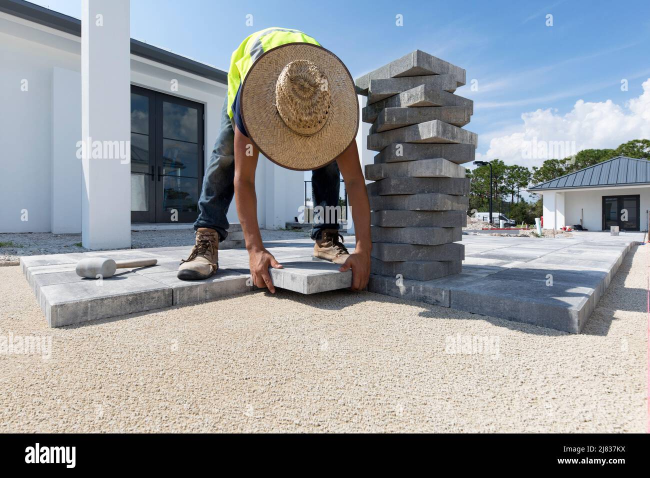 Walkway tiles, bricks or pavers are being installed on a property in. Naples, Florida between a few buildings and some sport installations. Stock Photo