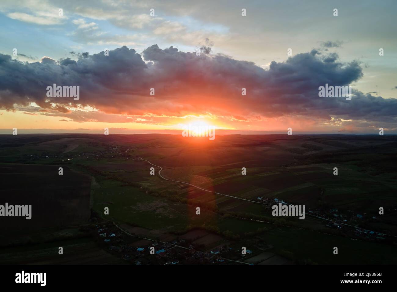 Bright colorful sunset sky with setting sun and vibrant clouds over ...