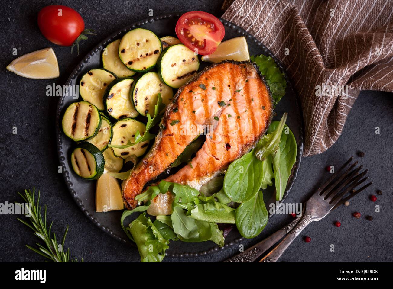 Cooked salmon fish with herbs and vegetables on dark background Stock ...