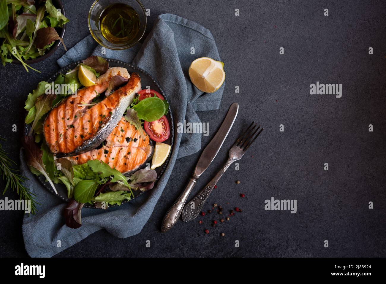 Cooked salmon fish with herbs and vegetables on dark background Stock ...