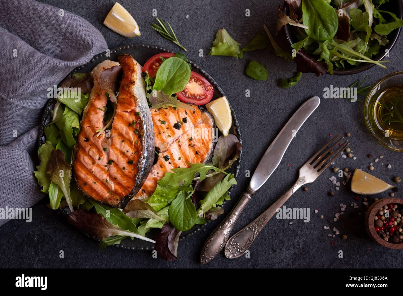 Cooked salmon fish with herbs and vegetables on dark background Stock ...