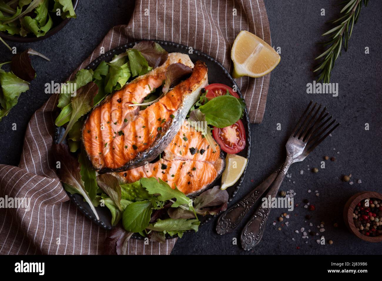 Cooked salmon fish with herbs and vegetables on dark background Stock ...