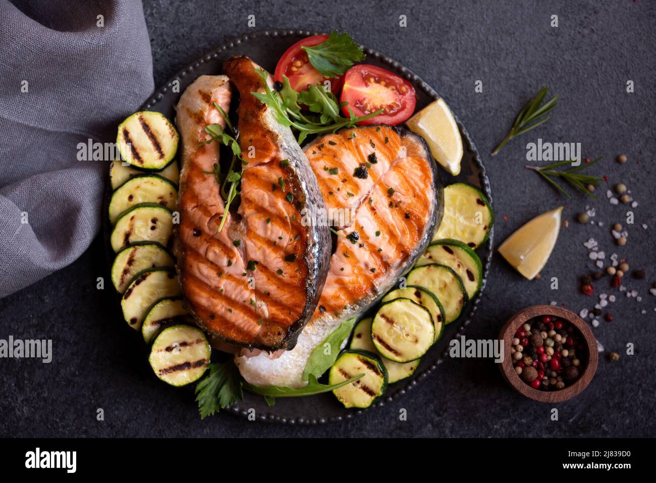 Cooked salmon fish with herbs and vegetables on dark background Stock ...