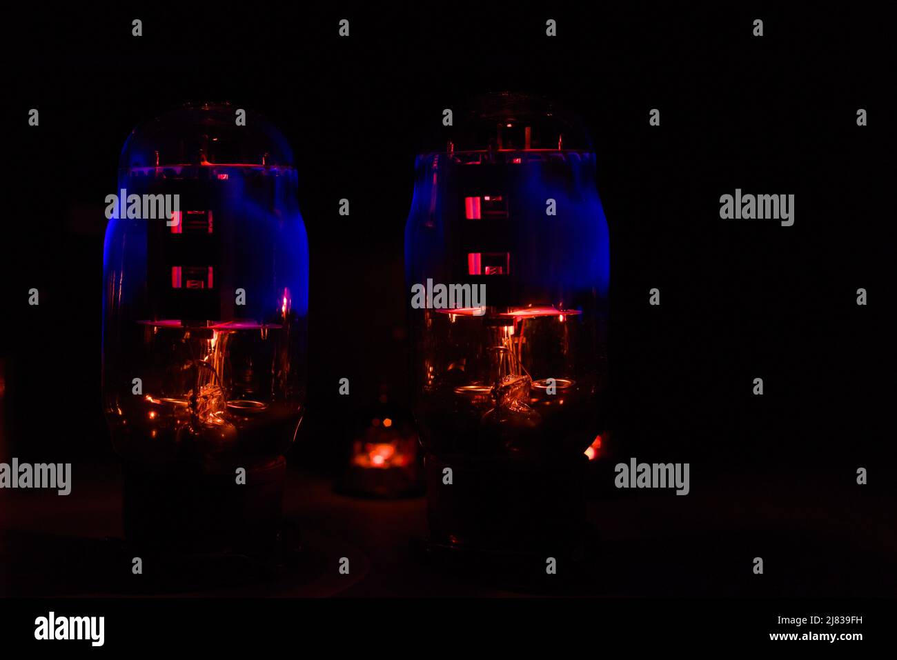 A pair of power vacuum tubes (electron tube) operating at full temperature and glowing in the