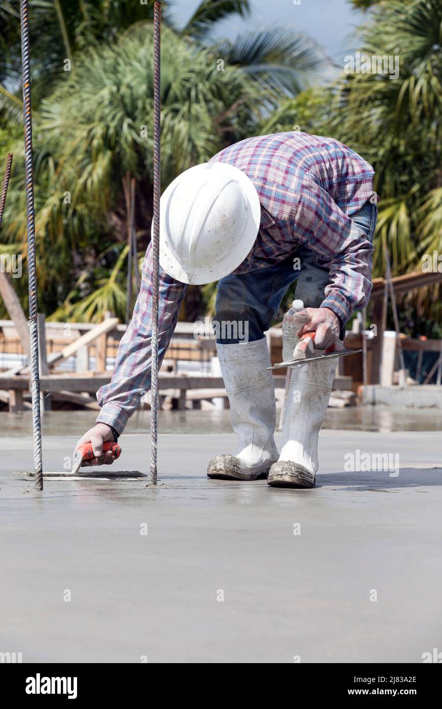 Construction worker smoothing freshly poured concrete with a trowel Stock Photo