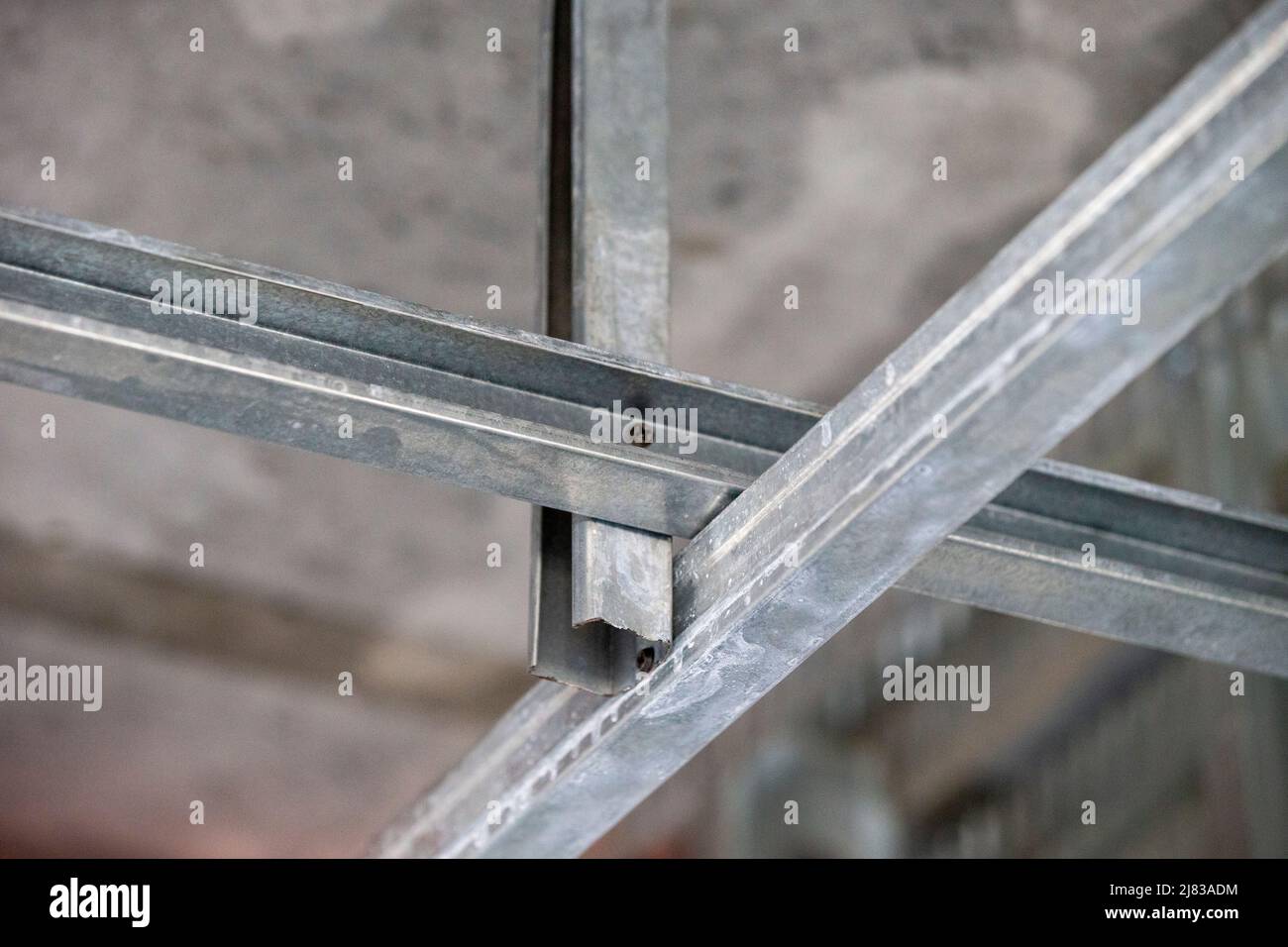 dropdown ceiling support rails for drywall installation from a concrete ceiling Stock Photo