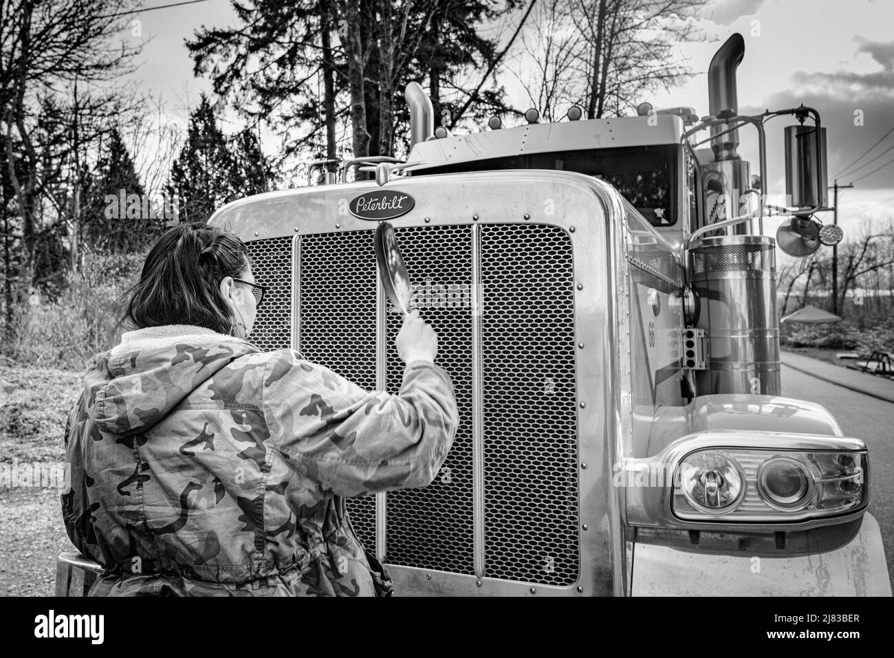 Indigenous woman with eagle feather blocks truck at entrance to Kinder Morgan Trans Mountain Pipeline Terminal, Burnaby, British Columbia, Canada. Stock Photo