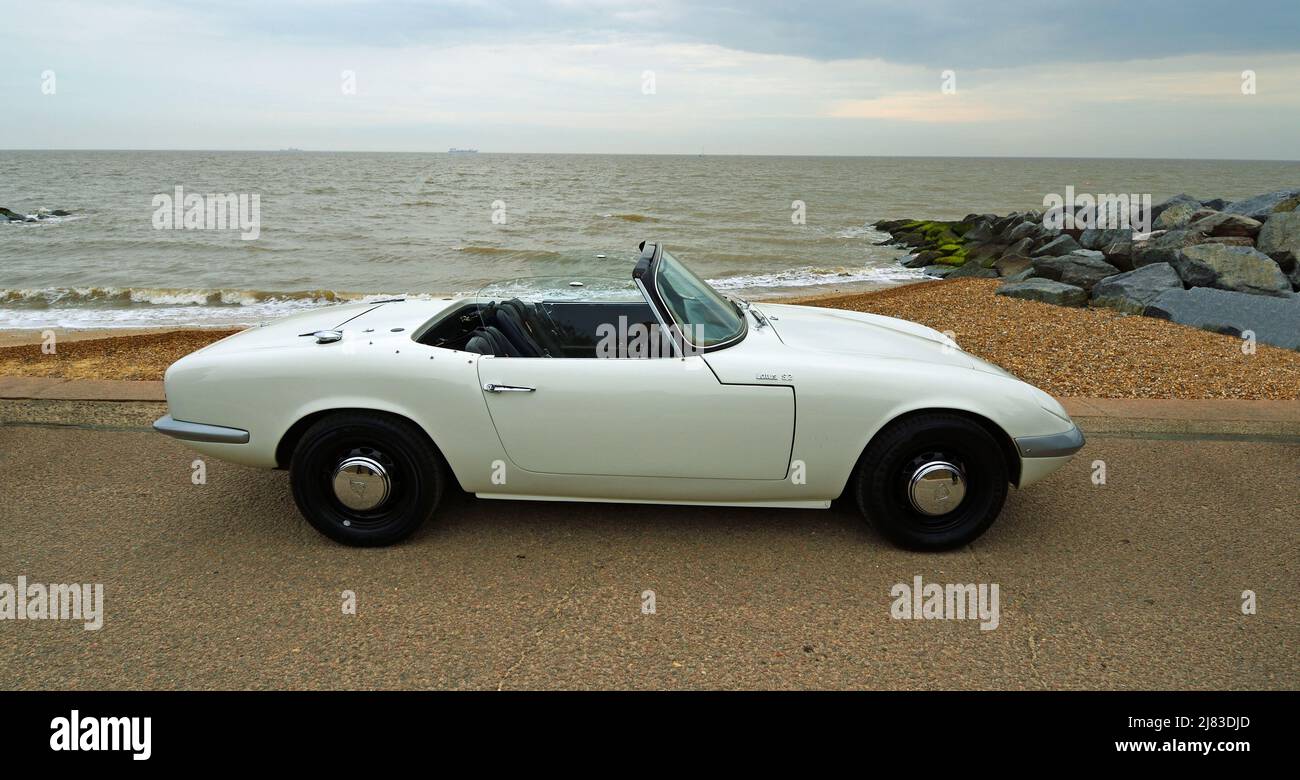 Classic white Lotus convertible parked on seafront promenade beach and sea in background. Stock Photo