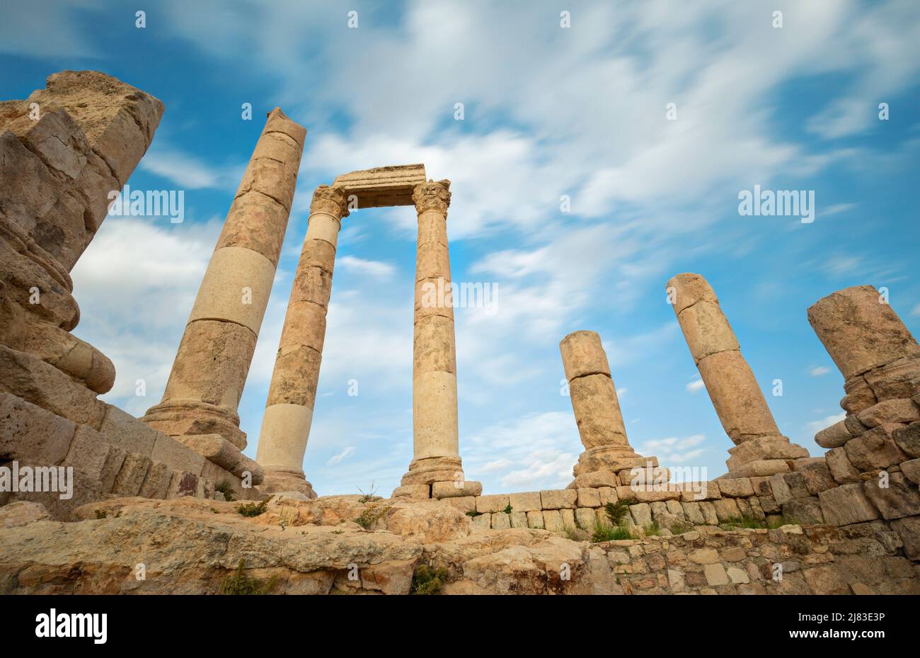 unsurpassed view of the ruins of the temple of Hercules on the top of the mountain of the Amman citadel against the background of a blue sky with clou Stock Photo