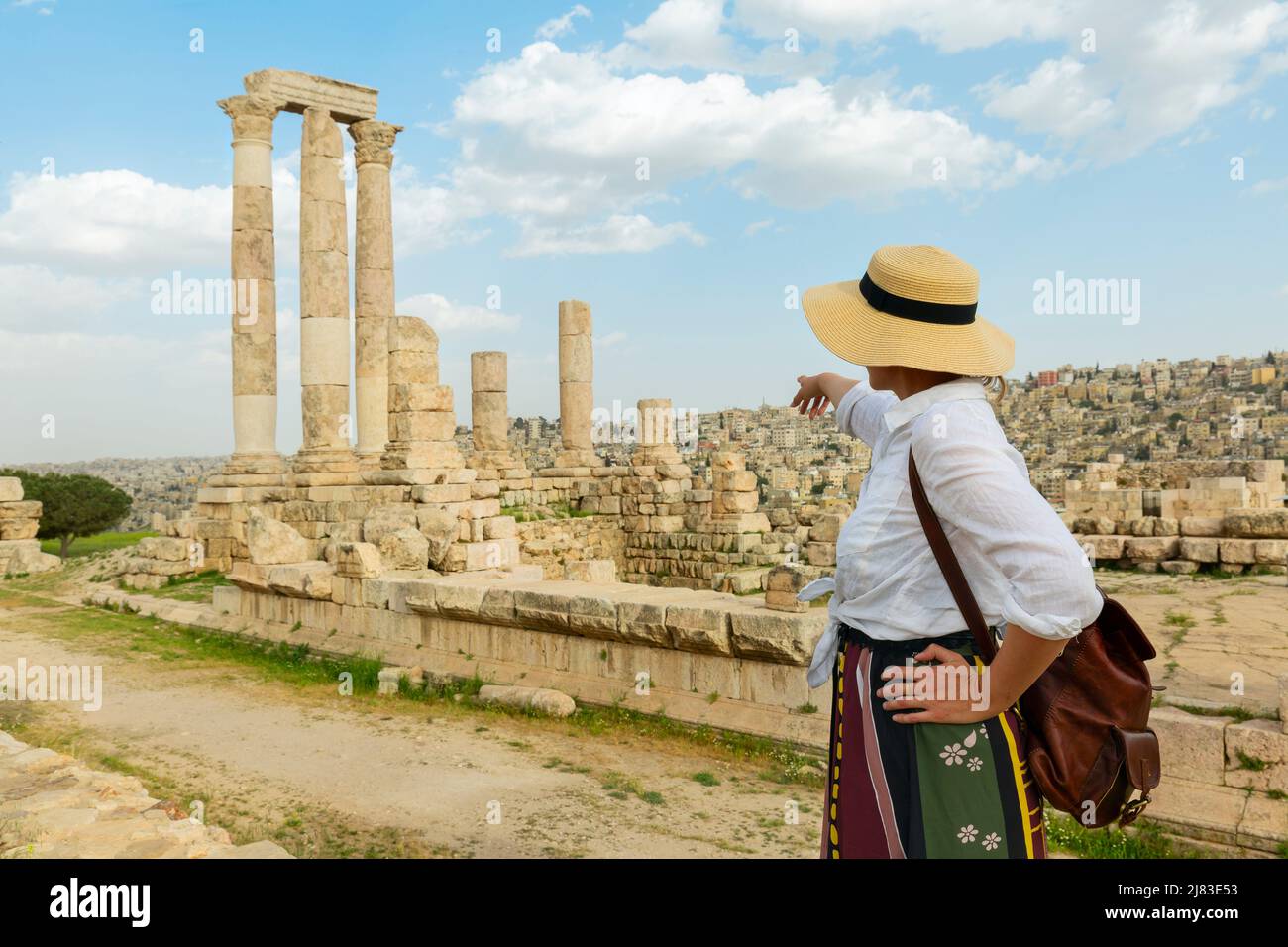 Amman, jordan. travel tourism holiday background -young girl with hat standing pointing to  the Temple of Hercules of the Amman Citadel complex Stock Photo