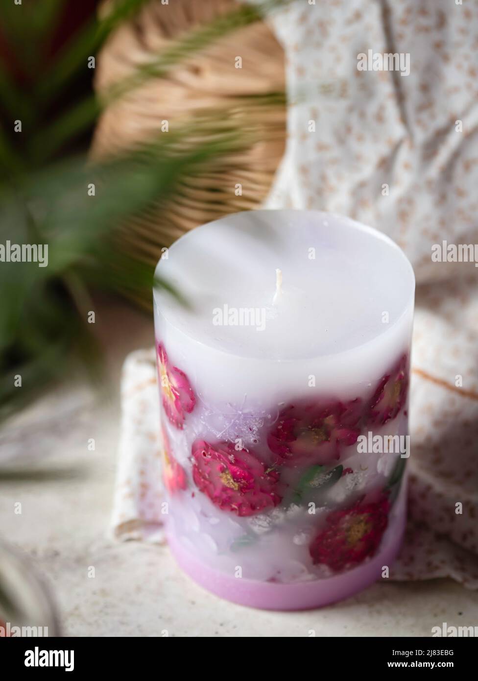 Handmade candles of a unique design, with different flowers, dry leaves