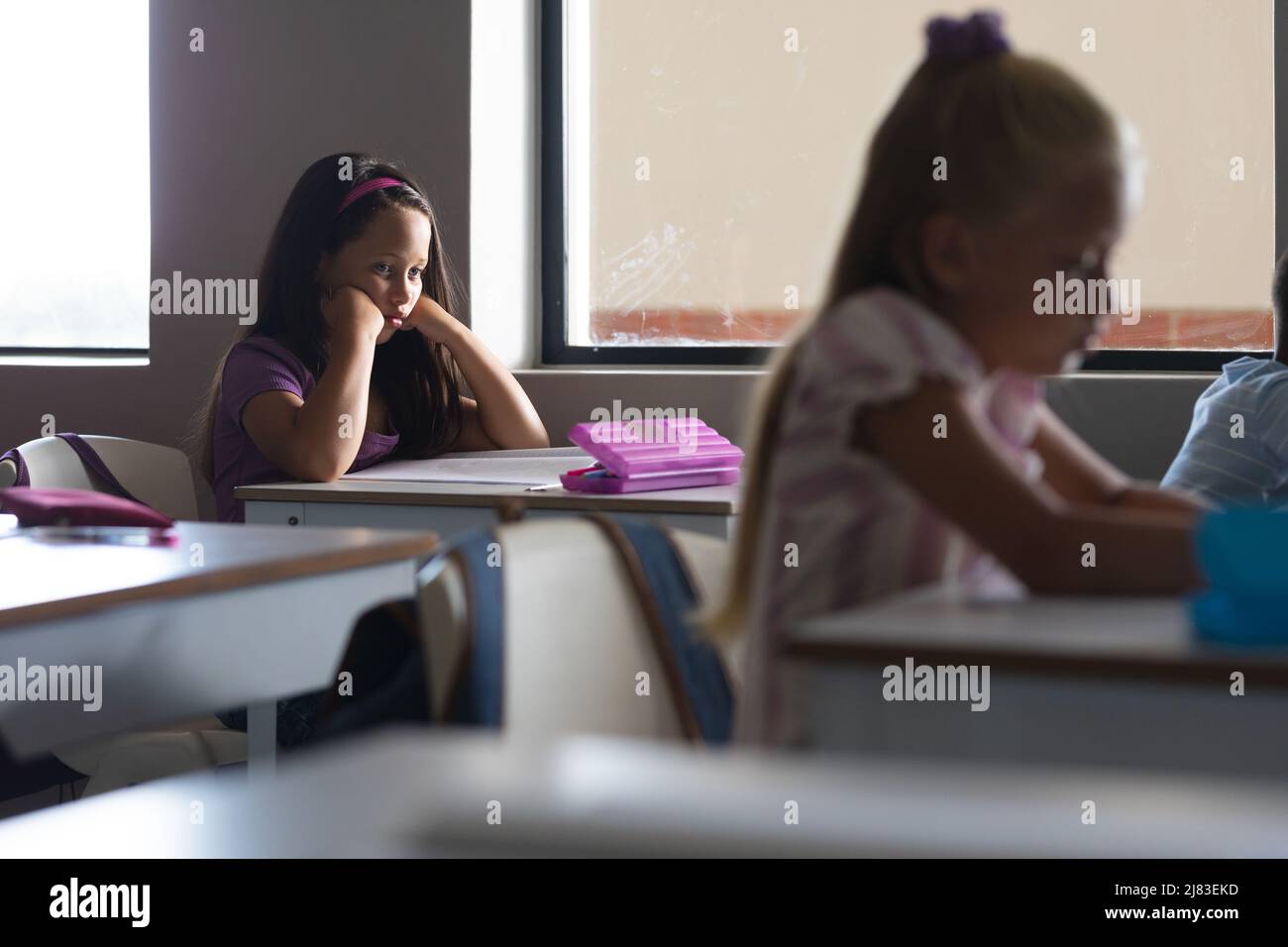 Caucasian elementary schoolgirls studying at desk in classroom Stock ...