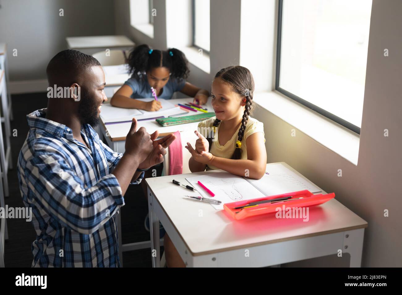 African american young male teacher communicating in sign language with